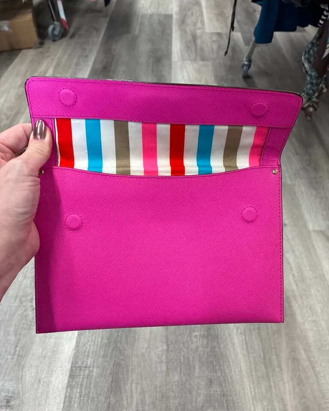 Neon pink Kate Spade envelope wristlet with a striped lining
