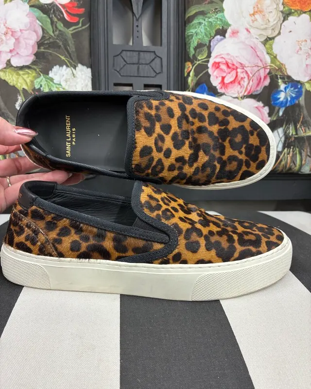 Saint Laurent leopard print slip-on sneakers held up in the shop